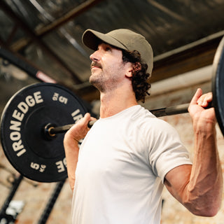 Man lifting a barbell during a strength training session in a gym